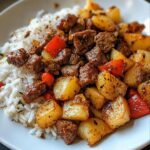 Gesunde Rindfleisch-Paprika-Reisschüssel mit knusprigen Kartoffelwürfeln