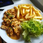 Hähnchenfilet in cremiger Knoblauchsauce mit Pommes und frischem Salat